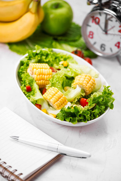 Frischer Salat, Notizbuch und Uhr - Foto, Bild