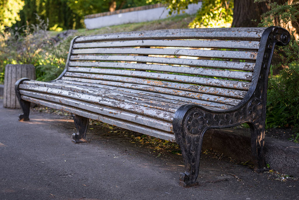 Una vecchia panchina grigia con vernice sbucciante, nel parco. Telaio orizzontale
 - Foto, immagini