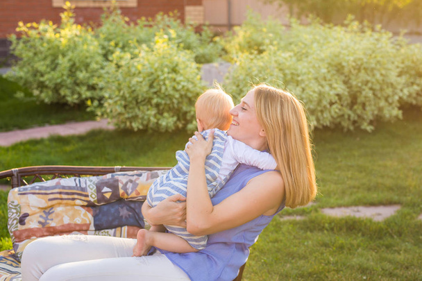 glückliche harmonische Familie im Freien. Mutter lacht und spielt mit Baby im Sommer in der Natur - Foto, Bild