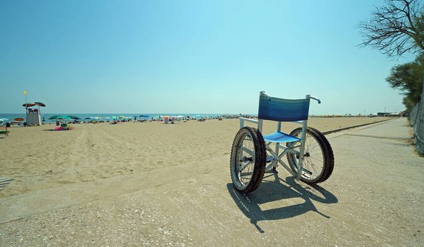 Ειδικό αναπηρικό αμαξίδιο με δομή αλουμινίου πάνω στην αμμώδη παραλία - Φωτογραφία, εικόνα
