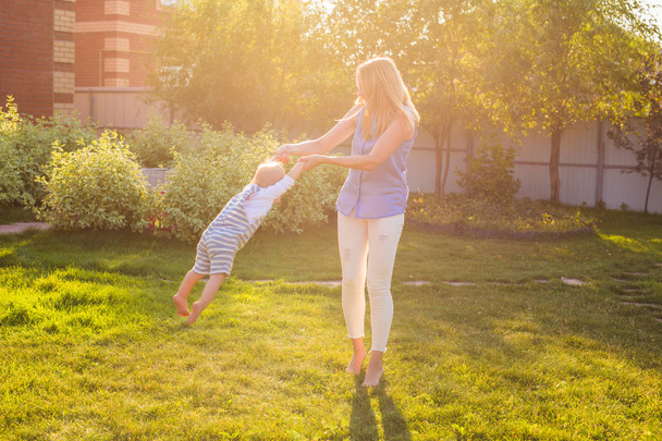 ευτυχισμένη αρμονική οικογένεια σε εξωτερικούς χώρους. μητέρα γελώντας και παίζοντας με το μωρό το καλοκαίρι στη φύση - Φωτογραφία, εικόνα