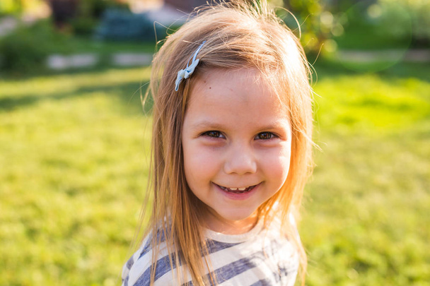 Portret schattig klein meisje in de lente of zomer dag - Foto, afbeelding