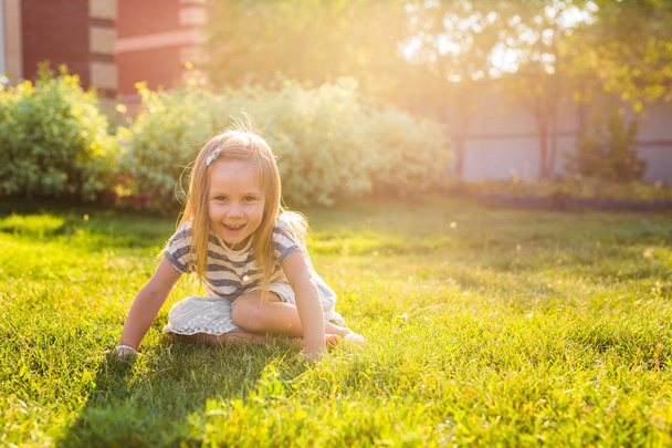happy child girl playing on meadow in summer in nature - Foto, afbeelding
