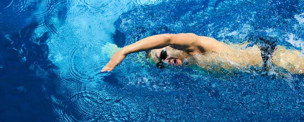 Male swimmer at the swimming pool. Underwater photo. - Foto, imagen