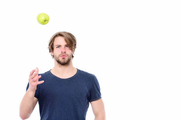 Young caucasian guy in blue tshirt throwing apple to air - Fotografie, Obrázek