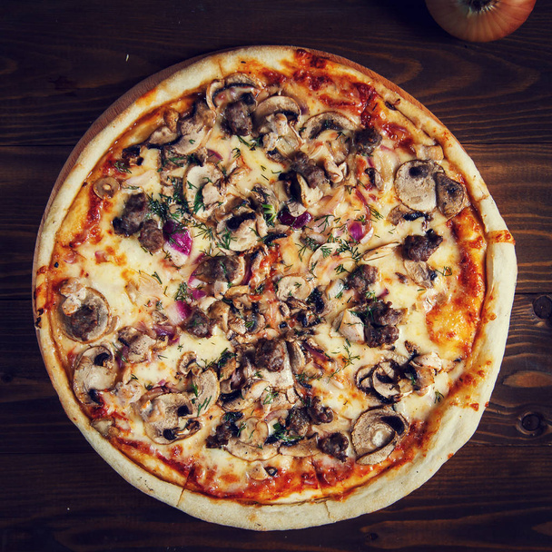 Deliciosa pizza casera con mozzarella, champiñones, carne de res y ch
 - Foto, imagen