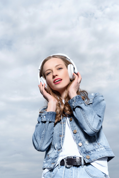 jeune femme écouter de la musique dans les écouteurs - Photo, image