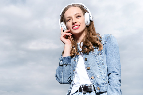 νεαρή γυναίκα ακούει μουσική στα ακουστικά - Φωτογραφία, εικόνα