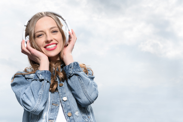 mosolygó nő zenehallgatás fejhallgató - Fotó, kép