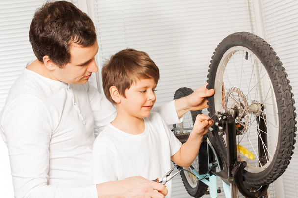 boy and father fixing bicycle - 写真・画像