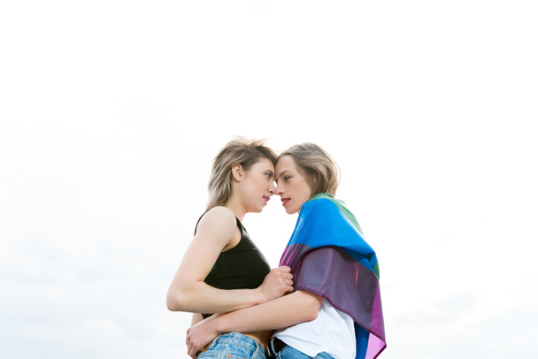 homosexual couple embracing with lgbt flag - Zdjęcie, obraz