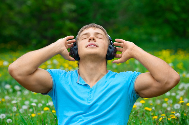 Portrait of a young man listening to music outdoors - Foto, Imagen