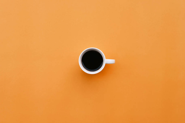 Cup of coffee on orange background - 写真・画像