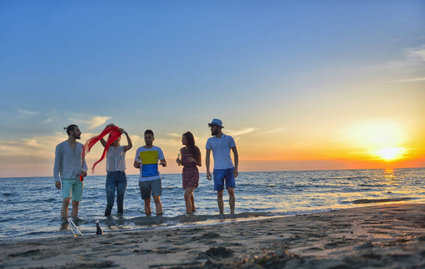 gelukkige jonge mensen op strand  - Foto, afbeelding
