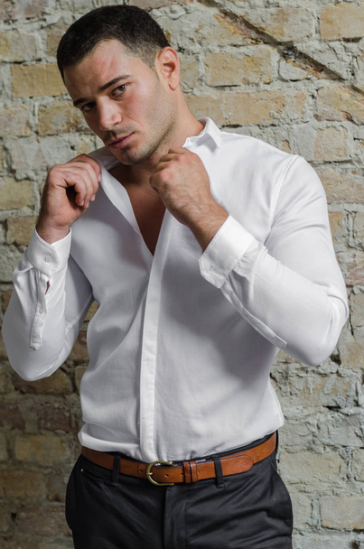 Man in a white shirt and pants posing  - Foto, afbeelding