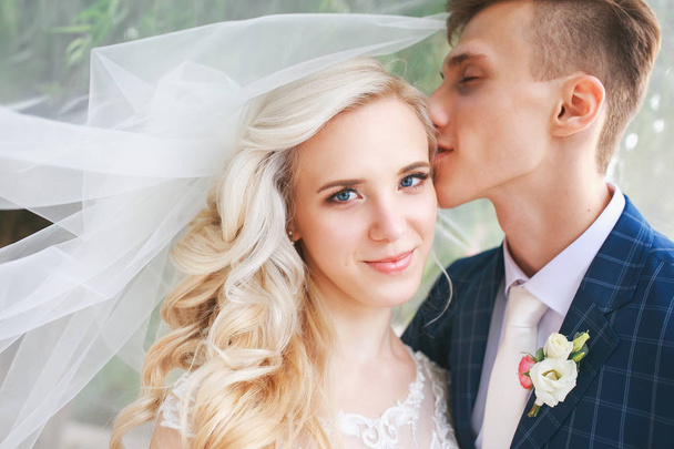 Wedding couple kissing covered veil .Wedding couple is hugging each other. Beauty bride with groom - Foto, immagini