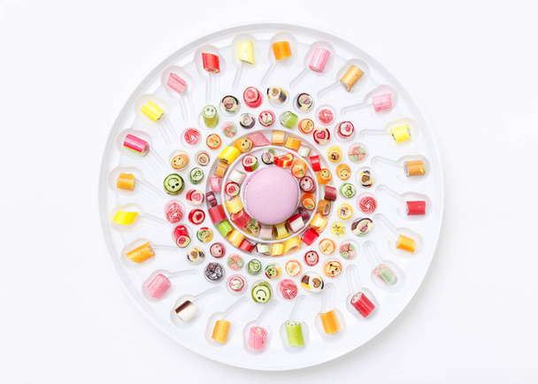 színes nyalókák fehér tányérra - Fotó, kép