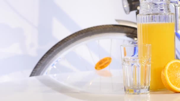 appelsiini ja appelsiinimehu kierto pöydällä polkupyörän taustalla
 - Materiaali, video