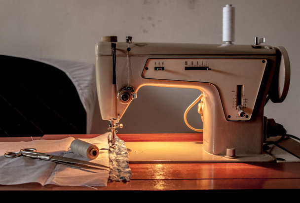 Máquina de coser, proceso de costura, tijeras e hilo junto a mach
 - Foto, imagen