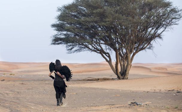 mulher com um arco e uma flecha em um deserto
 - Foto, Imagem