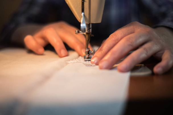 Máquina de coser, proceso de costura, manos de las mujeres sosteniendo un paño para
 - Foto, Imagen