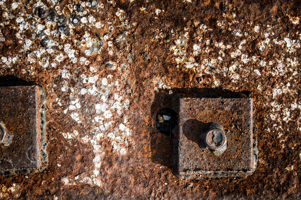 Rusty fragments of a hexagonal bolt head with flange - Photo, Image
