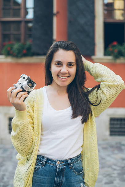 young pretty woman taking picture with old camera - Zdjęcie, obraz