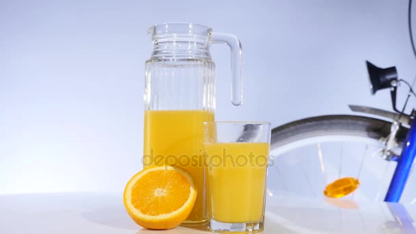 orange and orange juice rotation on the table bicyrcle on background - Filmati, video