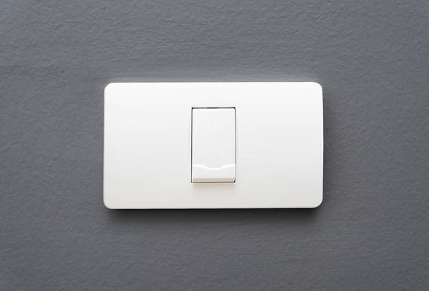 Light switch on gray concrete wall background. - Photo, Image