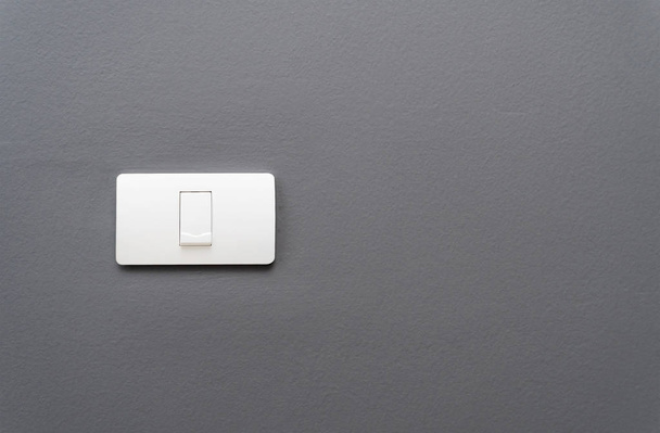 Світловий вмикач на сіро-бетонному фоні стіни
. - Фото, зображення