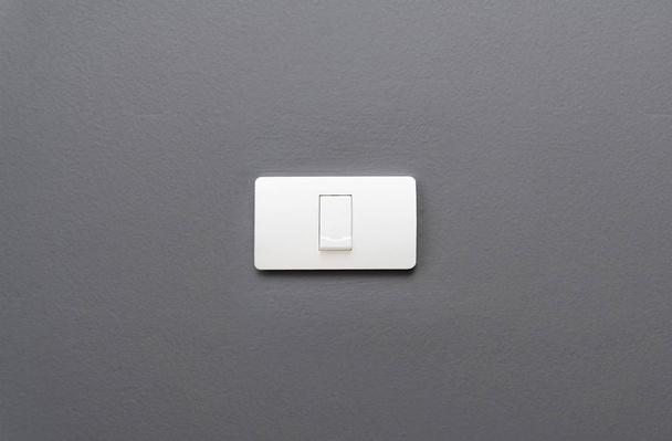 Interruptor de luz sobre fondo de pared de hormigón gris
. - Foto, imagen