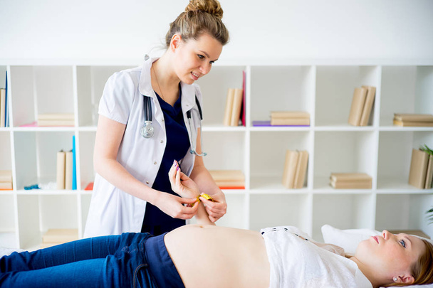 Doctor checking pregnant woman with measuring tape - Fotografie, Obrázek