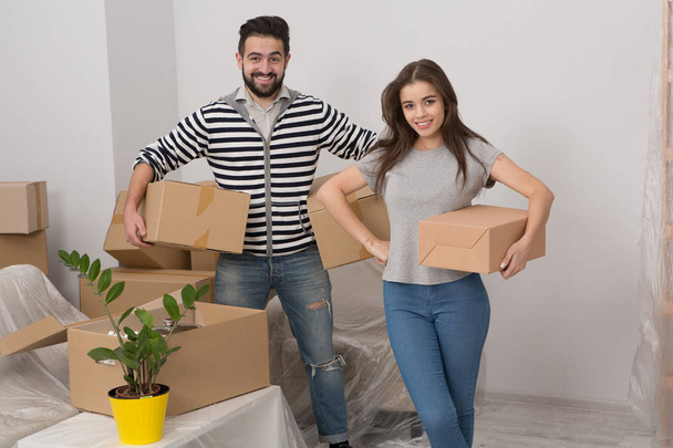 Young couple is moving into new house with lot of boxes. - Фото, изображение