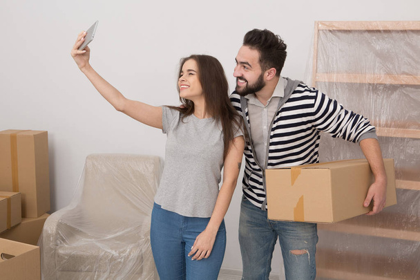 Couple making selfie in new apartment leaving old life behind. - Valokuva, kuva