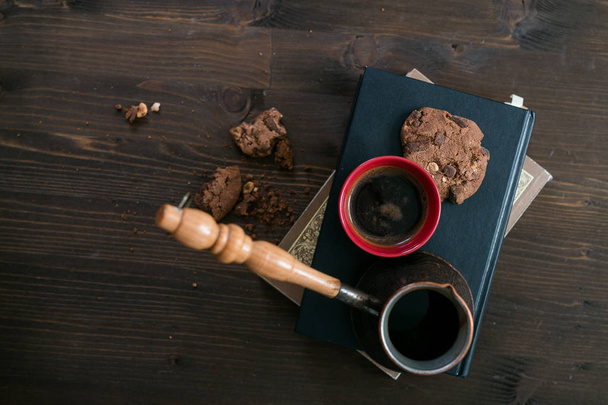 the coffee Cup and coffee maker and cookies are on stack of books - Photo, Image