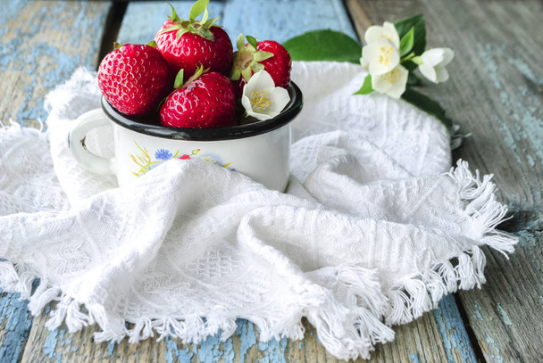 Fresas rojas maduras frescas en taza de esmalte blanco sobre fondo de madera, comida rústica natural
 - Foto, imagen