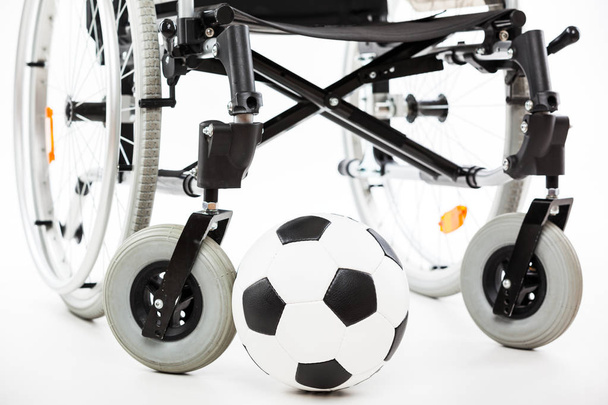 Wheelchair for invalid or disabled person and soccer ball - Foto, Bild