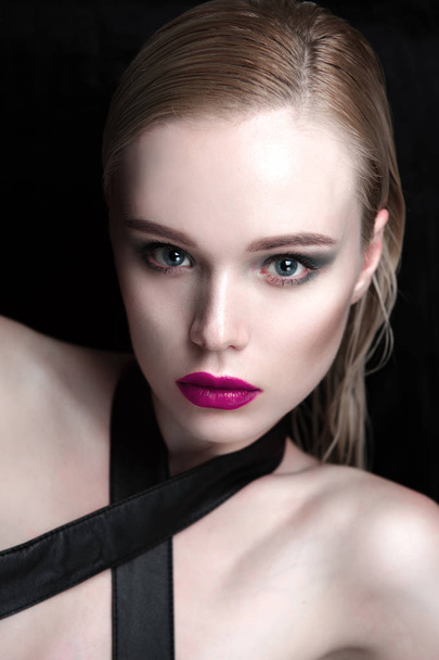 Portrait of beautiful girl model with pink lips and blue eyes with leather belt on her neck, fresh clean highlighted skin. Fashion retouched close up shot. - Photo, Image