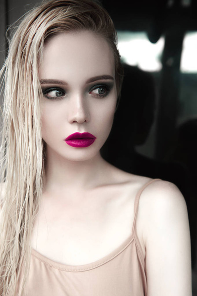 Portrait of beautiful girl model with pink lips and blue eyes with leather belt on her neck, fresh clean highlighted skin. Fashion retouched close up shot. Sad depressed mood - Photo, Image