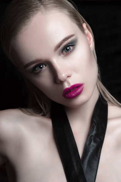 Portrait of beautiful girl model with pink lips and blue eyes with leather belt on her neck, fresh clean highlighted skin. Fashion retouched close up shot. - Foto, Imagen
