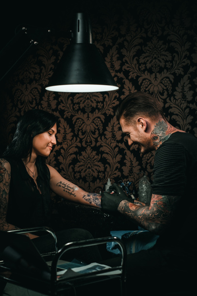 Επαγγελματίας καλλιτέχνης τατουάζ κάνει ένα τατουάζ σε ένα νεαρό κορίτσι χέρι - Φωτογραφία, εικόνα