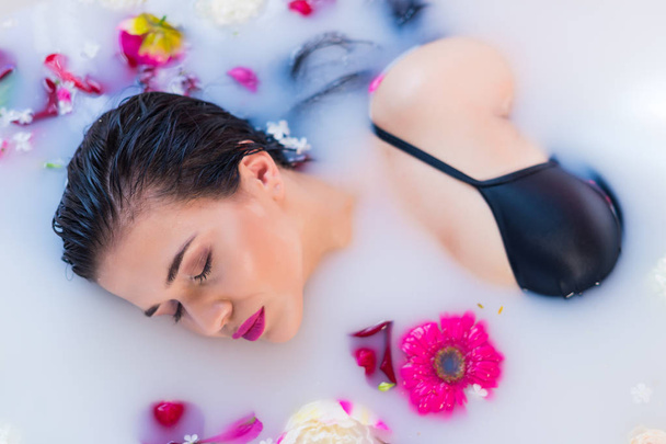 Szexi barna nő pihentető egy meleg fürdő, virágok - Fotó, kép