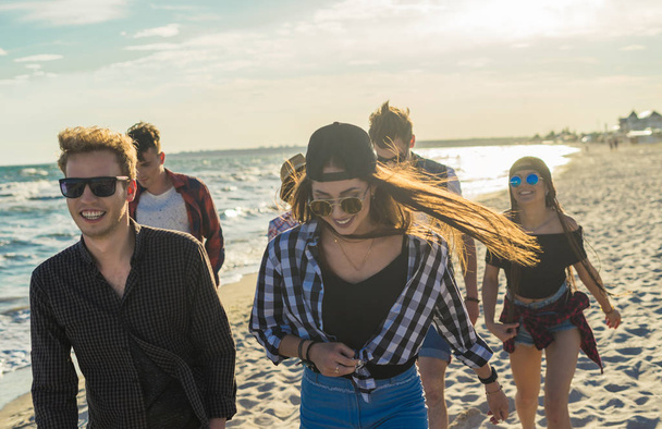 Grupo de jóvenes amigos hipster corriendo por la playa juntos
 - Foto, imagen