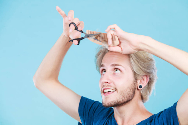 Man with scissors and comb creating new coiffure - 写真・画像