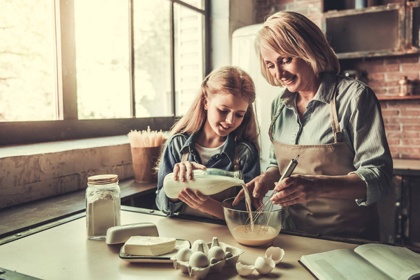 Grandma and granddaughter in kitchen - Photo, image