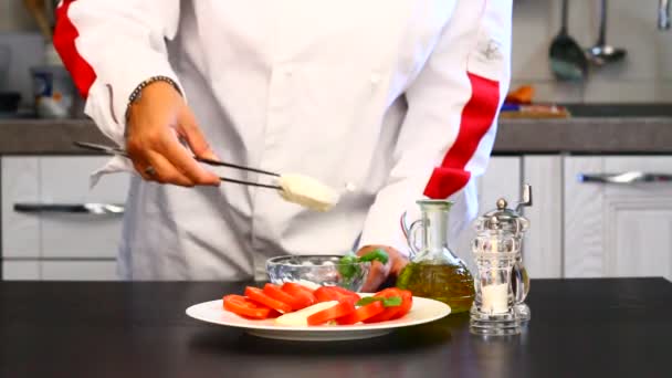Επαγγελματίας μάγειρας ετοιμάζει ένα πιάτο με φρέσκες ντομάτες και μοτσαρέλα  - Πλάνα, βίντεο