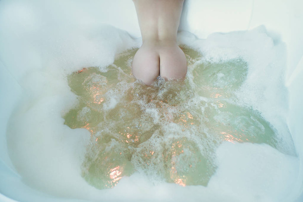Mujer joven desnuda con un gran jacuzzi en espuma. Chica en la espuma en el baño
 - Foto, imagen