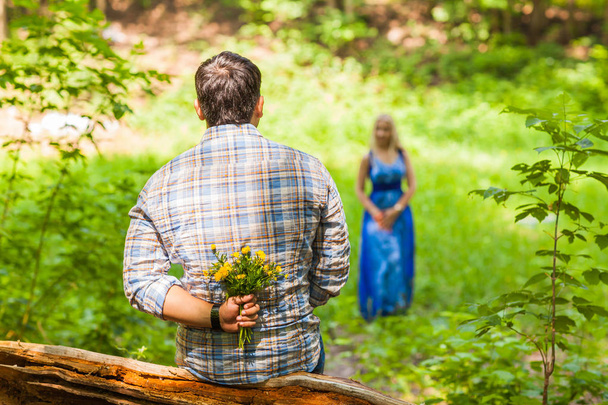 Young man giving a flower dandelion to girlfriend outdoors - Fotografie, Obrázek