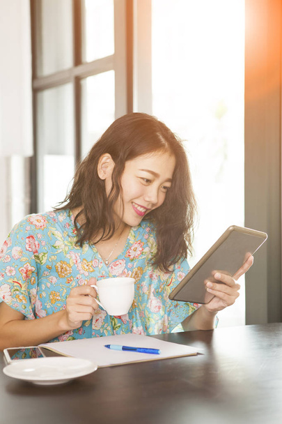азіатська молодша жінка читає повідомлення на планшеті зубний сморід
 - Фото, зображення
