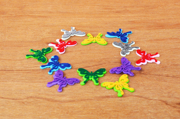 Immagini di farfalle fatte di tessuti di feltro colorati. Isolato su sfondo grana di legno
.  - Foto, immagini